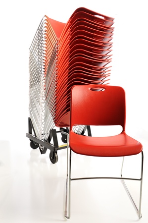 Stack of vibrant orange plastic chairs for a conferenceの写真素材