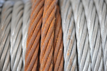 a rusty braded cable overlaps coils of newer steel cable