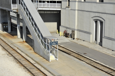 Industrial train platform and outdoor stairwell between two sets of tracksの写真素材