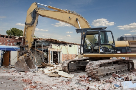 A large backhoe demolishes an old buildingの写真素材