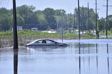 A car sits stranded after getting stuck on a flooded roadの写真素材