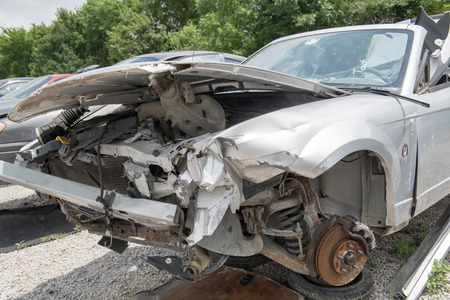 Front end of a wrecked car in a salvage yard, the wheels removedの写真素材