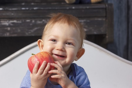 Little baby boy in parent's bedroom with paraffin wax apples