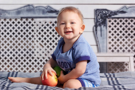 Little baby boy in parent's bedroom with paraffin wax applesの写真素材