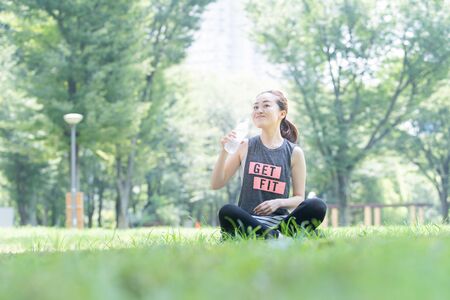 A woman doing yoga stretches in the parkの写真素材