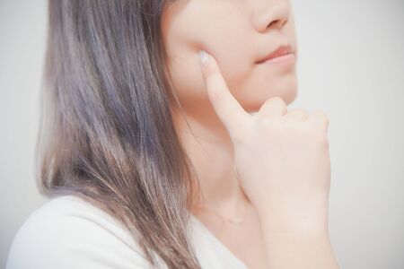 a woman who touches her skin with her fingersの写真素材