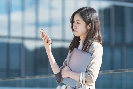 Business woman touching a smartphoneの写真素材