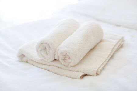 White towels on the bedの写真素材