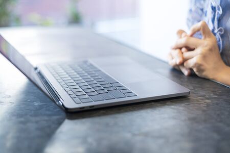 Close-up photo of female hands typing on keyboard at indoor workplace
