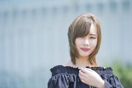 Portrait of an Asian young woman taken outdoors on a sunny dayの写真素材