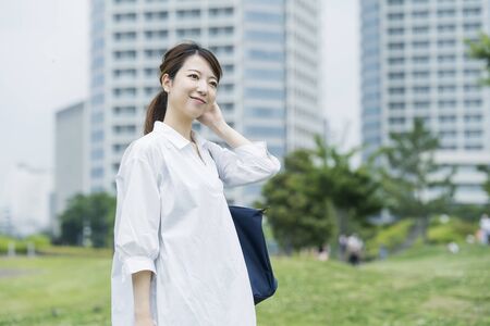 Asian woman wearing a white shirt and taking a walk in a relaxing atmosphereの写真素材