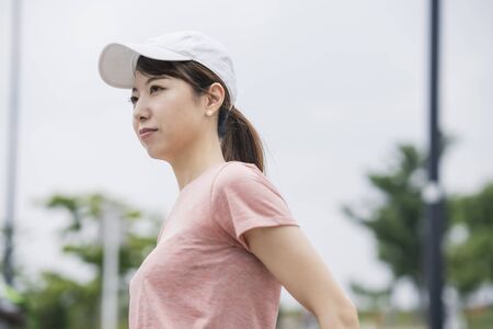 Asian young woman wearing sportswear and exercising in the parkの写真素材