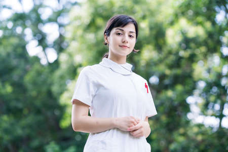 Outdoor portrait of young woman posing in white coat on fine dayの写真素材