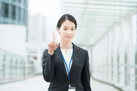 Asian young business woman in a suit posing with a smile and cheeringの写真素材