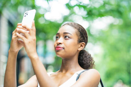 Young business woman operating by looking at the screen of the smartphone
