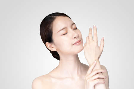 Asian young woman touching face with her hand in relaxed expressionの写真素材