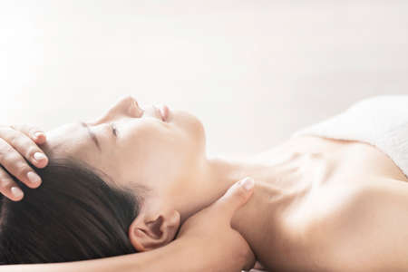 Young woman having her head massaged at the beauty salonの写真素材