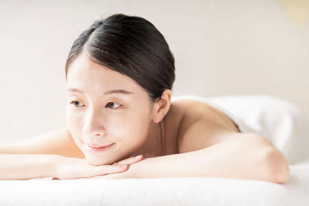 Young woman being massaged in a beauty salon with a bright atmosphereの写真素材