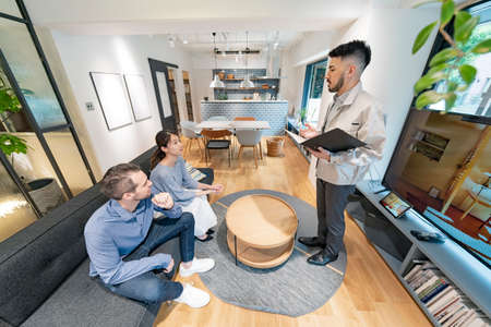 Young man and woman listening to the interior designer's explanation