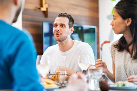 Men and women having a house party and having fun chatting