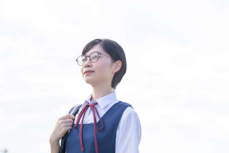 Asian high school girls wearing uniforms and smiling at schoolの写真素材