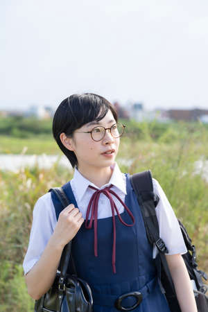 Asian high school girls wearing uniforms and smiling at school