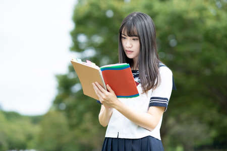 Asian female high school student studying in the park
