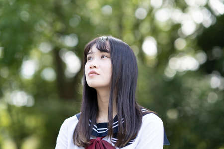 female asian high school student with a calm look outdoors