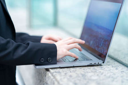 Asian young woman in suit working towards a laptop