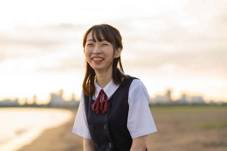 Asian female high school student walking on the beachの写真素材
