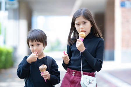 Children eating corn type ice cream with a spoonの写真素材