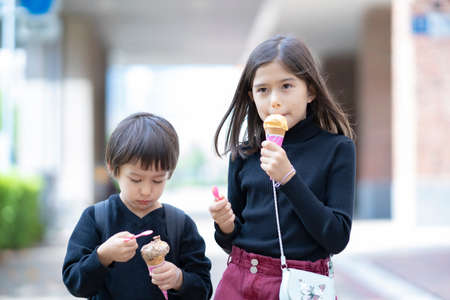 Children eating corn type ice cream with a spoonの写真素材