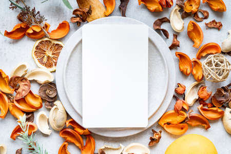 Ceramic plates and botanical ornaments set on a marble tableの写真素材