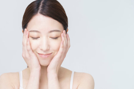 white back ground beauty image / Asian woman touching her faceの写真素材