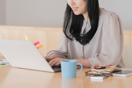 Asian black haired woman working from home using a laptopの写真素材