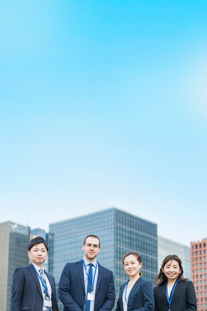 A business team of four men and women in suitsの写真素材