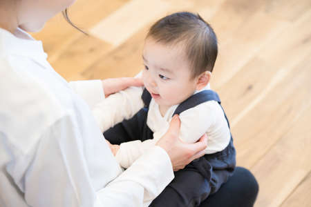 Asian young mom holding a baby with smile