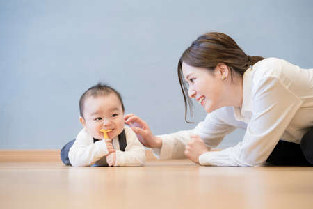 Asian young mom playing with baby on the floorの写真素材