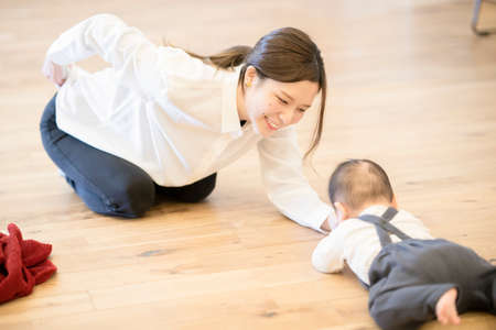 Asian young mom playing with baby on the floorの写真素材