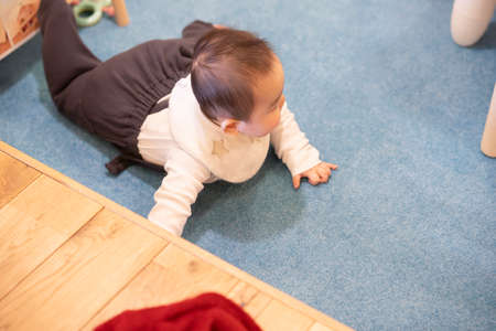 Japanese baby crawling on the wooden floor in the room