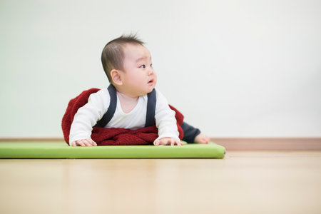Japanese baby crawling on the wooden floor in the roomの写真素材
