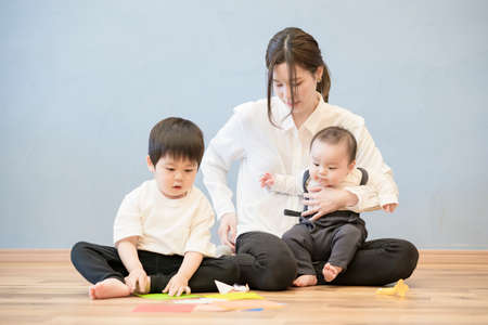 mom and her children who gather and play with each other indoorsの写真素材