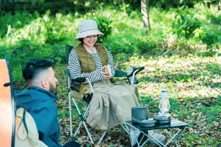 Man and woman enjoying camping in the forest