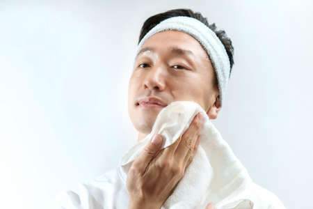 Japanese middle-aged man wiping his face with a towel