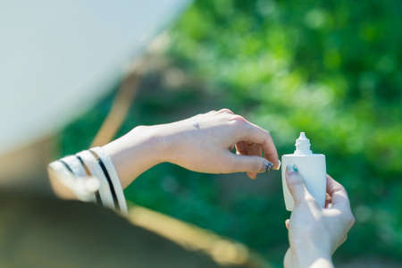 Asian woman applying hands sunscreen at the greenly park