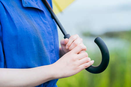 The hands of a woman holding an umbrella outdoorsの写真素材