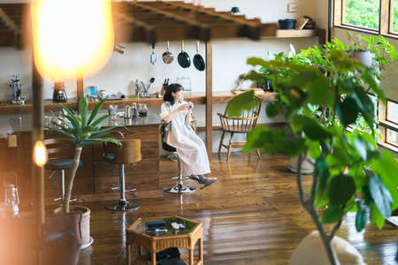 A young woman brewing and drinking coffee in a calm atmosphereの写真素材