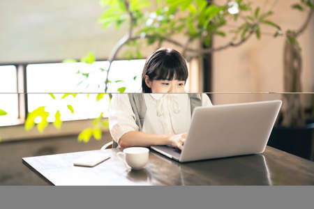 A woman looking at a laptop screen in a warm atmosphereの写真素材