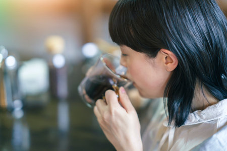 Young woman drinking coffee in a warm atmosphereの写真素材