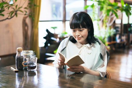 A young woman reading a book in a warm atmosphereの写真素材